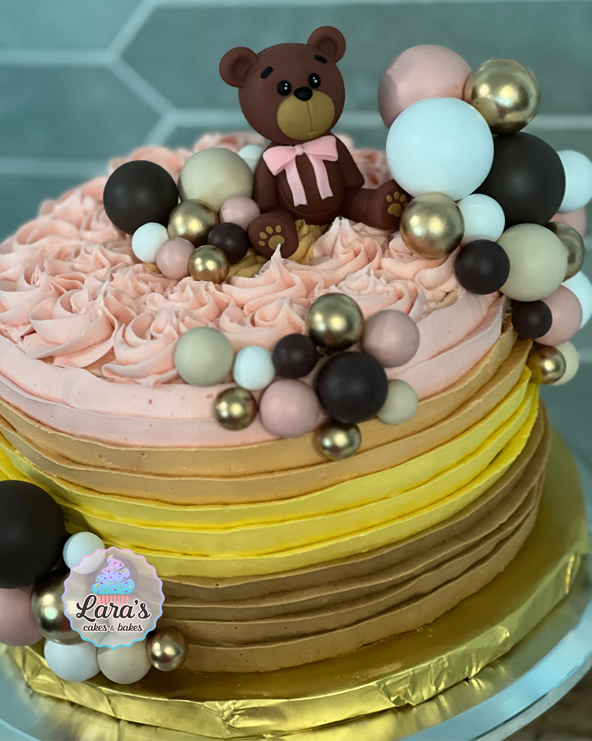 Baby shower bear cake with buttercream ruffles and colorful balloons