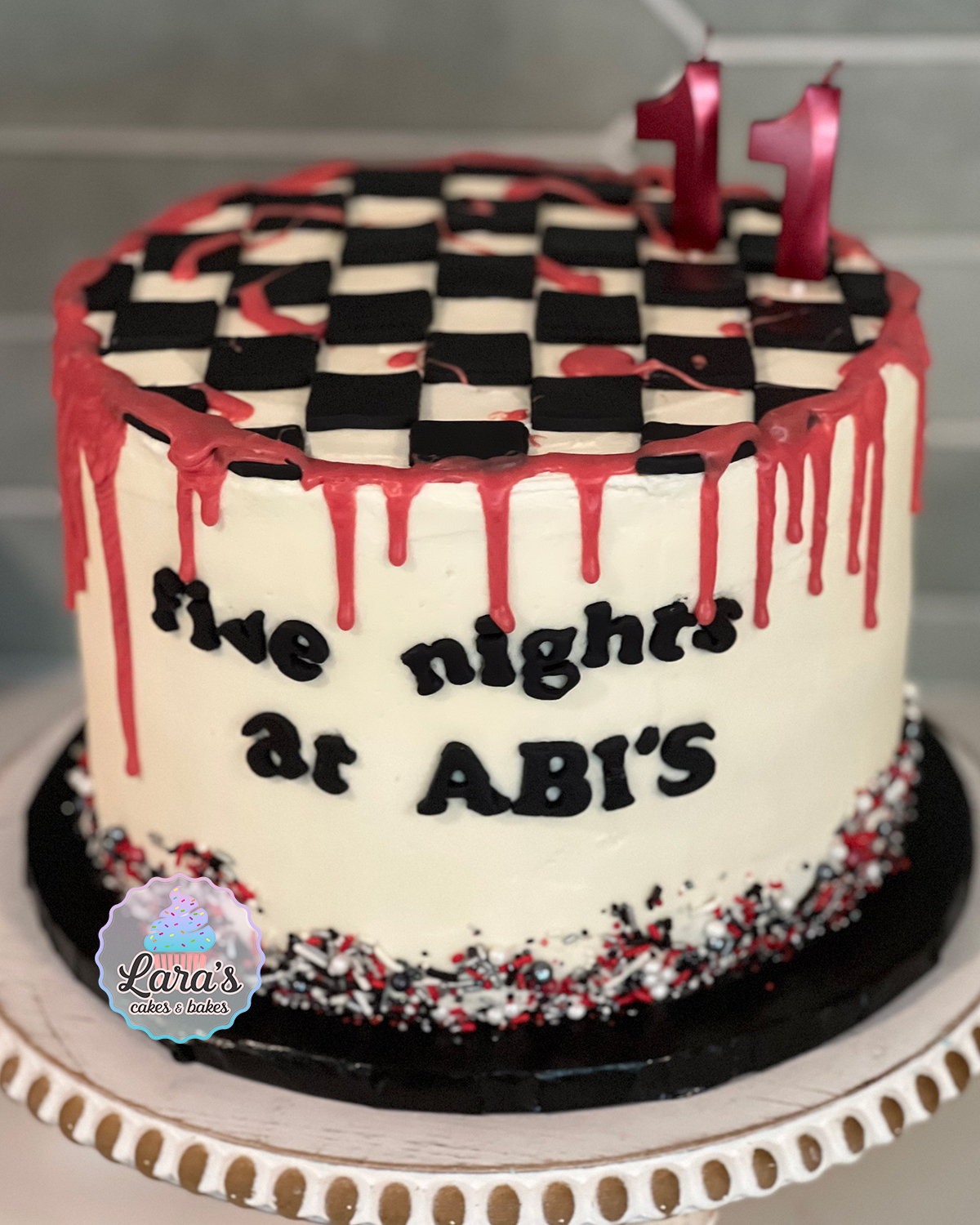 Five Nights at Freddy's cake with chocolate "blood" drip, fondant checkerboard, and sprinkles.