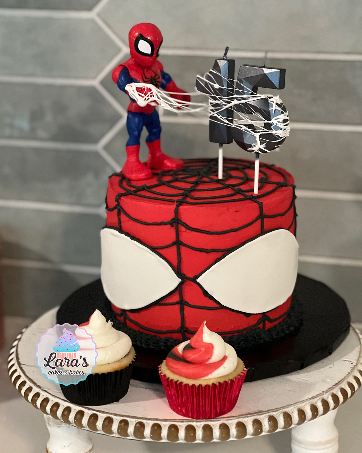Spiderman cake with marshmallow web, fondant eyes, and swirl cupcakes
